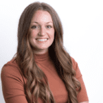 Megan Wiliams sitting in a chair with a brown blouse